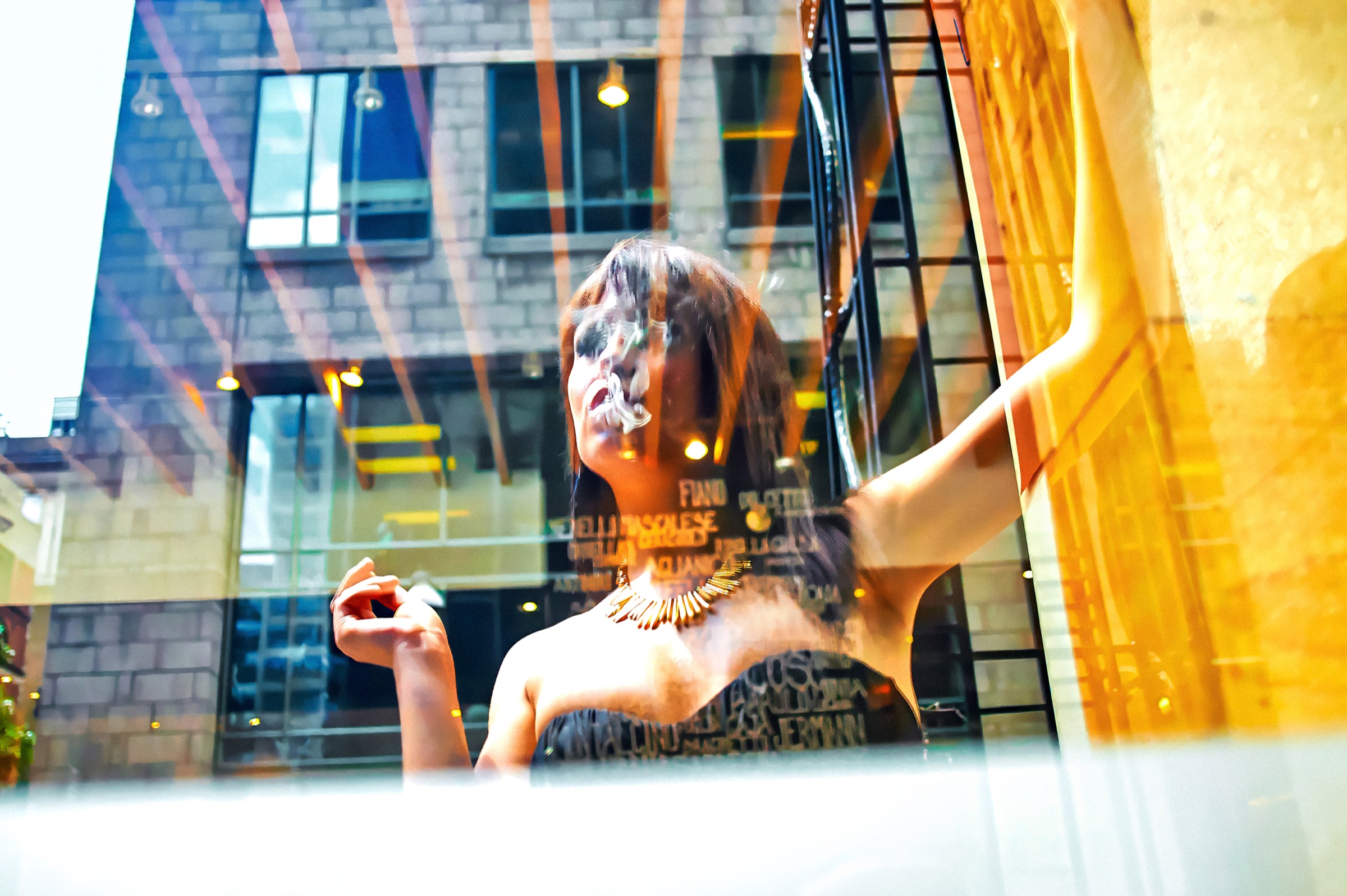 Krystal derrière une vitrine, enveloppée par les reflets colorés de la ville