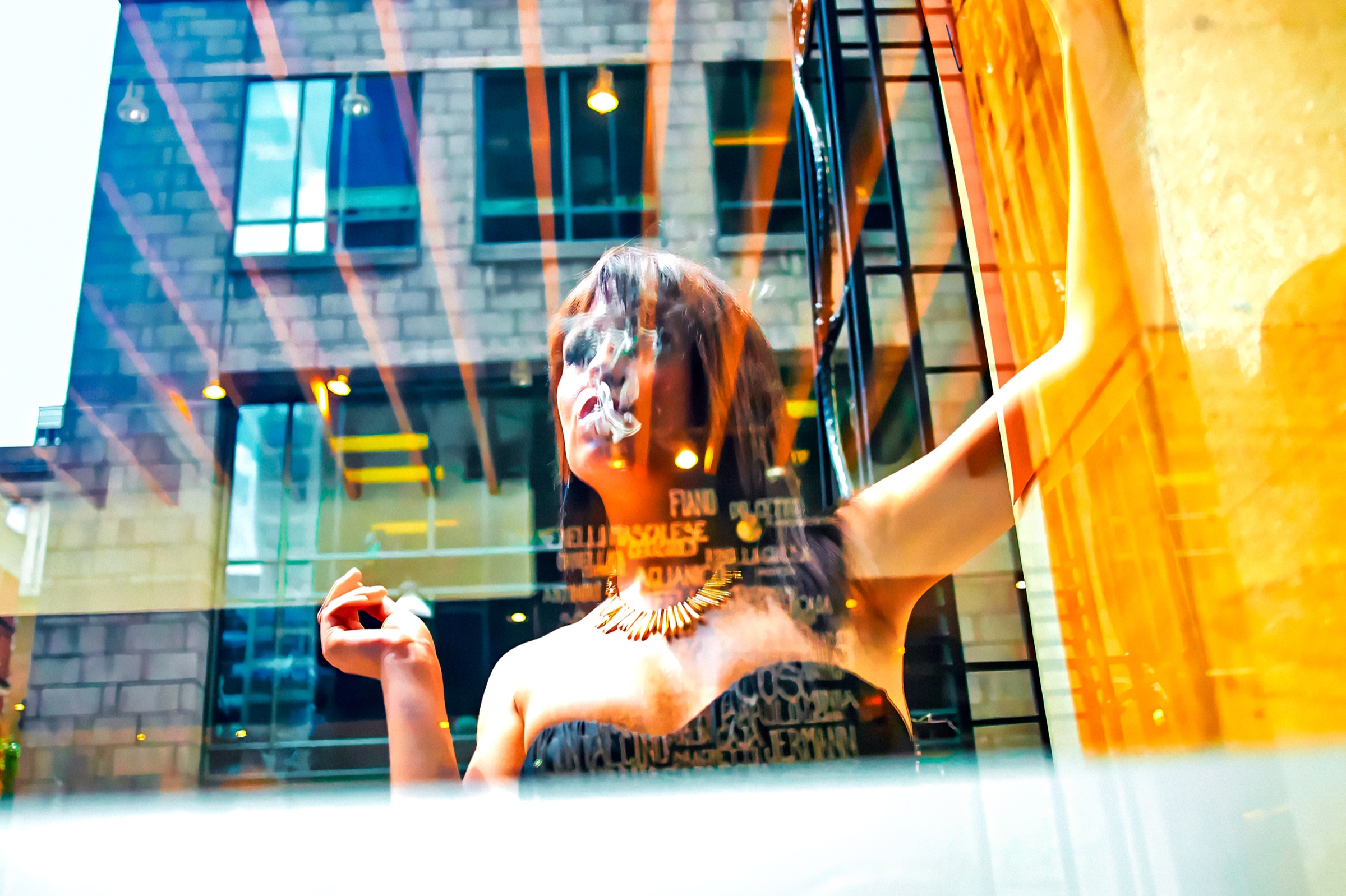 Krystal derrière une vitrine, enveloppée par les reflets colorés de la ville